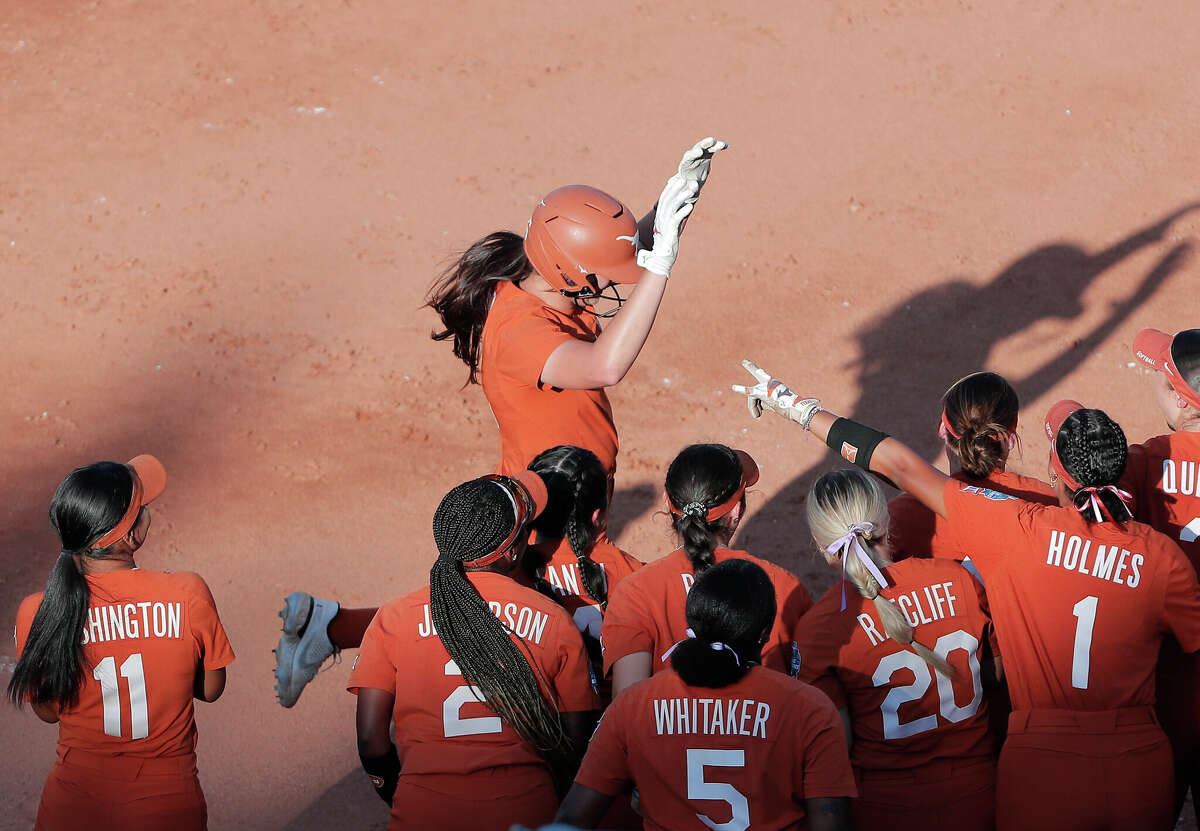 Texas' Courtney Day, top, celebrates after hitting home run during the second inning of an NCAA softball Women's College World Series game against Oklahoma State on Monday, June 6, 2022, in Oklahoma City. (AP Photo/Alonzo Adams)