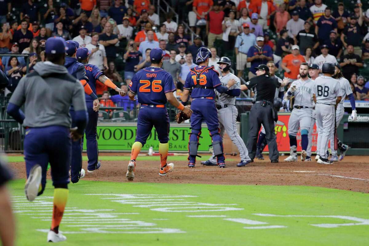 Both dugouts empty and umpires try to keep order after Seattle Mariners batter Ty France was hit by a pitch from Houston Astros relief pitcher Hector Neris during the ninth inning of a baseball game Monday, June 6, 2022, in Houston. (AP Photo/Michael Wyke)