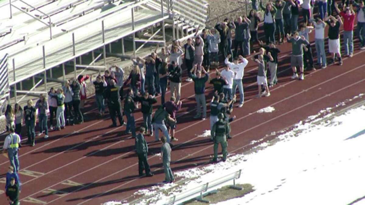 In this still image taken from video provided by Fox 31 Denver, students gather just outside of Arapahoe High School as police respond to reports of a shooting at Arapahoe High School in Centennial, Colo. Friday, Dec. 13, 2013.