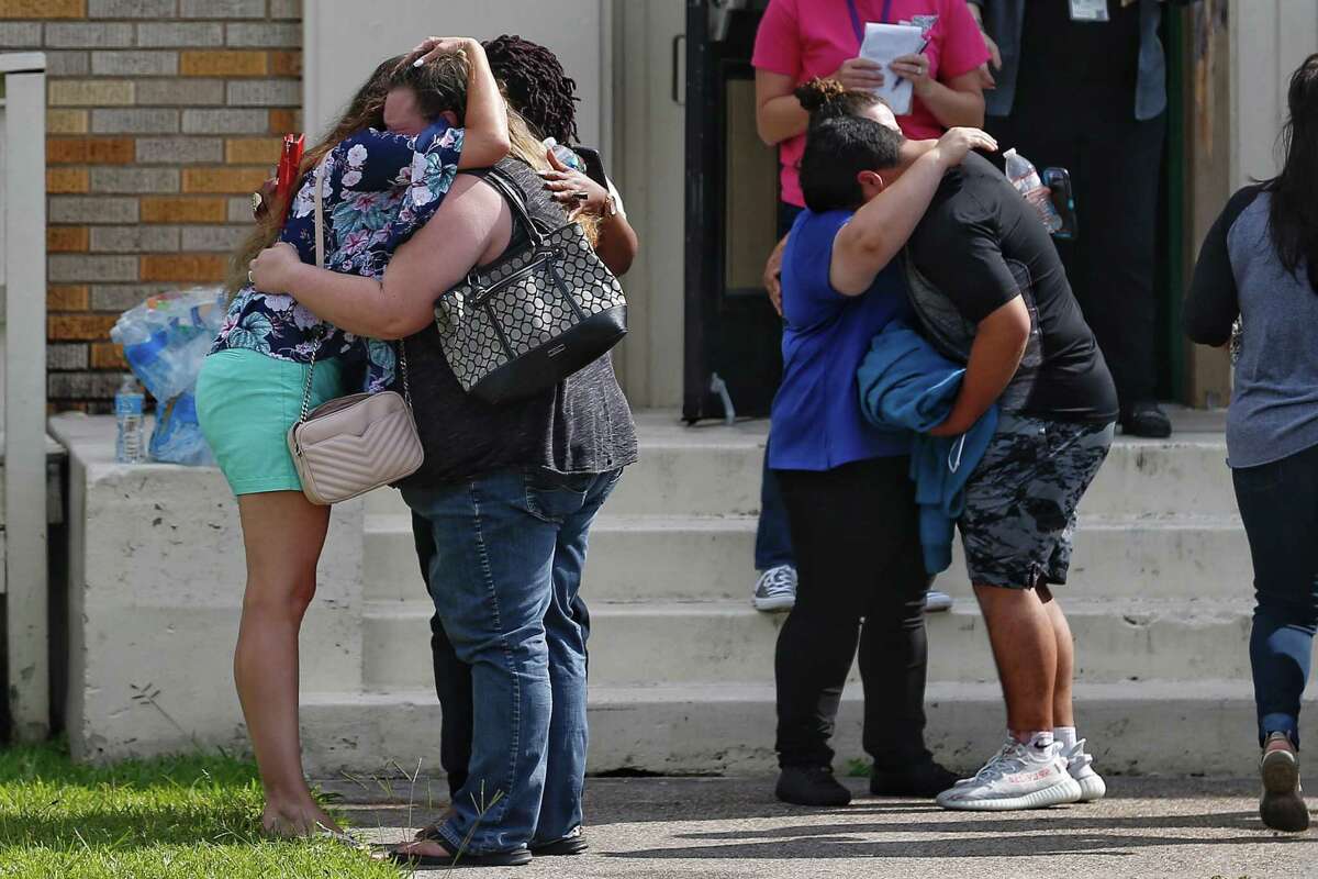 People embrace outside the Alamo Gym where students and parents wait to reunite following a shooting at Santa Fe High School Friday, May 18, 2018 in Santa Fe.