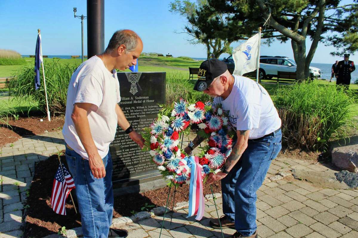 Vietnam War Army veteran Al Beck Sr., right, and his son, Al Beck Jr., lay a wreath at the base of the William A. Soderman Memorial in Bradley Point Park during West Haven’s dedication of the 14th phase of the brick Veterans Walk of Honor June 4.