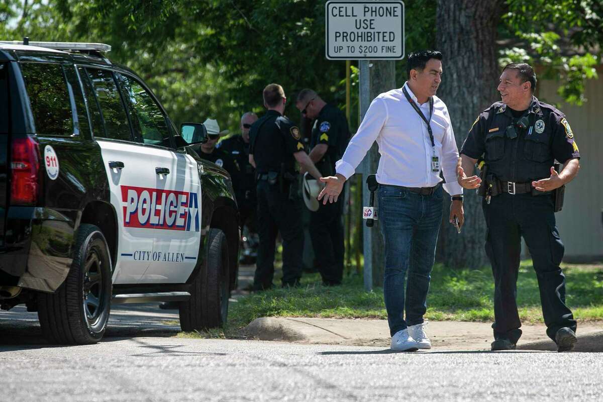 Telemundo journalist Jorge Miramontes talks with members of law enforcement after being told journalists cannot be on public property near Sacred Heart Catholic Church in Uvalde.
