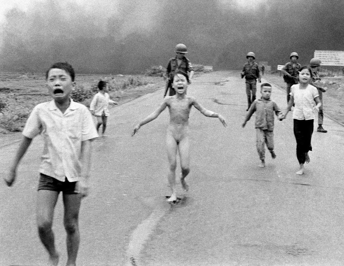 South Vietnamese forces follow terrified children, including 9-year-old Kim Phuc, center, as they run down Route 1 near Trang Bang after an aerial napalm attack on suspected Viet Cong hiding places on June 8, 1972. A South Vietnamese plane accidentally dropped its flaming napalm on South Vietnamese troops and civilians, and the terrified girl had ripped off her burning clothes while fleeing. (AP Photo/Nick Ut, File)