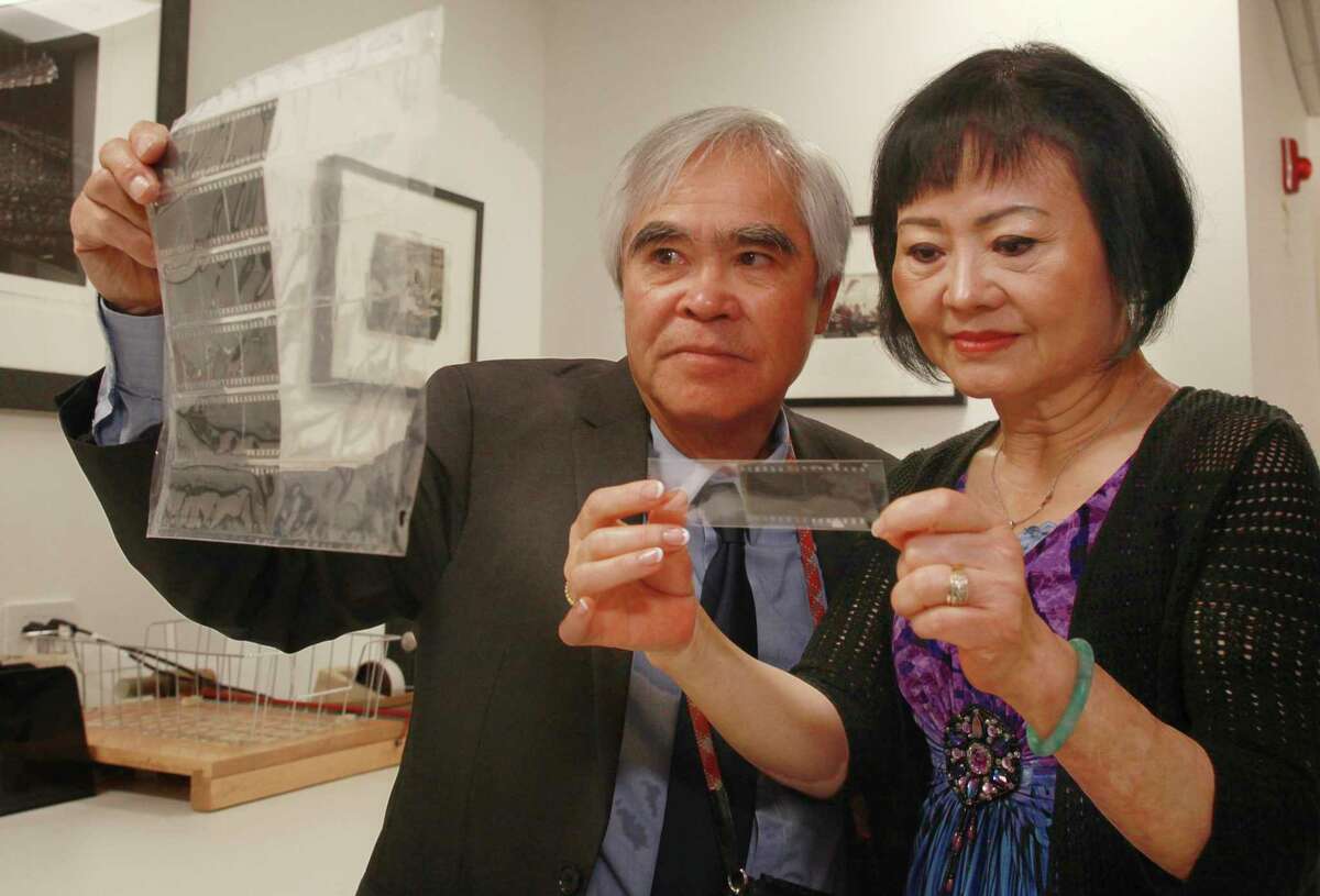 Kim Phuc, right, who at 9 years old was the subject of the Pulitzer Prize-winning "Napalm Girl" photo by now retired Associated Press photographer Nick Ut, left, holds the original negative of the iconic photo at The AP headquarters photo library, in New York, Monday, June 6, 2022, The pair examined Ut's negatives from the June 8, 1972, attack on Trang Bang, South Vietnam. Now friends forever linked by the iconic photo, they are in New York for events marking the 50th anniversary of the photo.