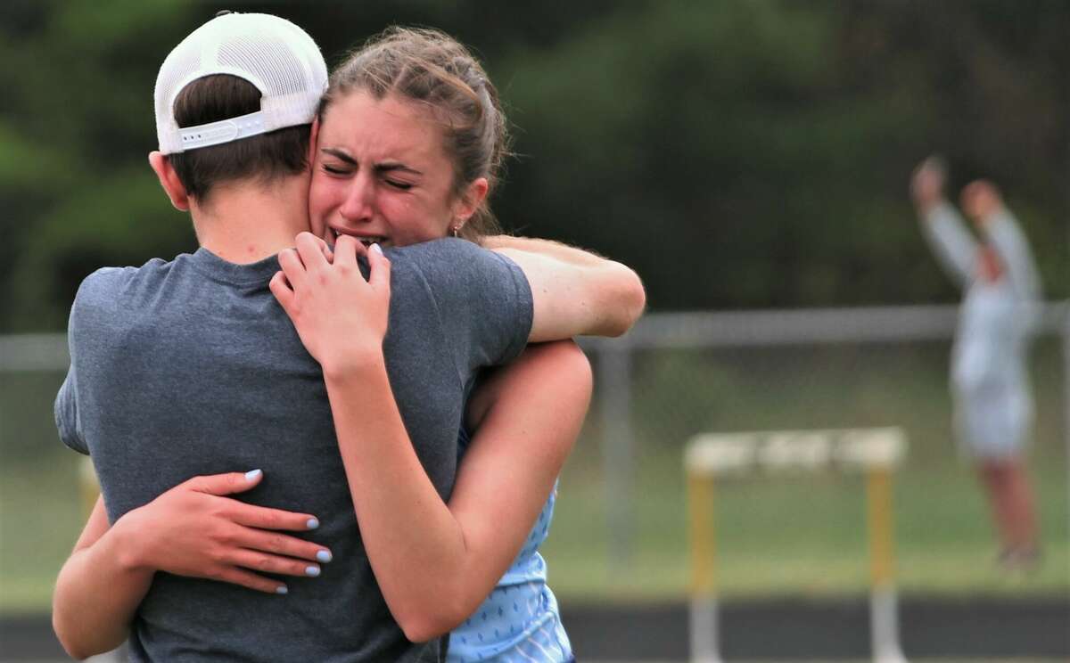 FILE - Brethren coach Kyle Griffin hugs Allyson Osga after the girls 4x200 relay during regionals on May 21 at Brethren High School. A botched exchange resulted in the Bobcats baton landing on the ground, disqualifying the Bobcats from the event after initially qualifying for state finals.