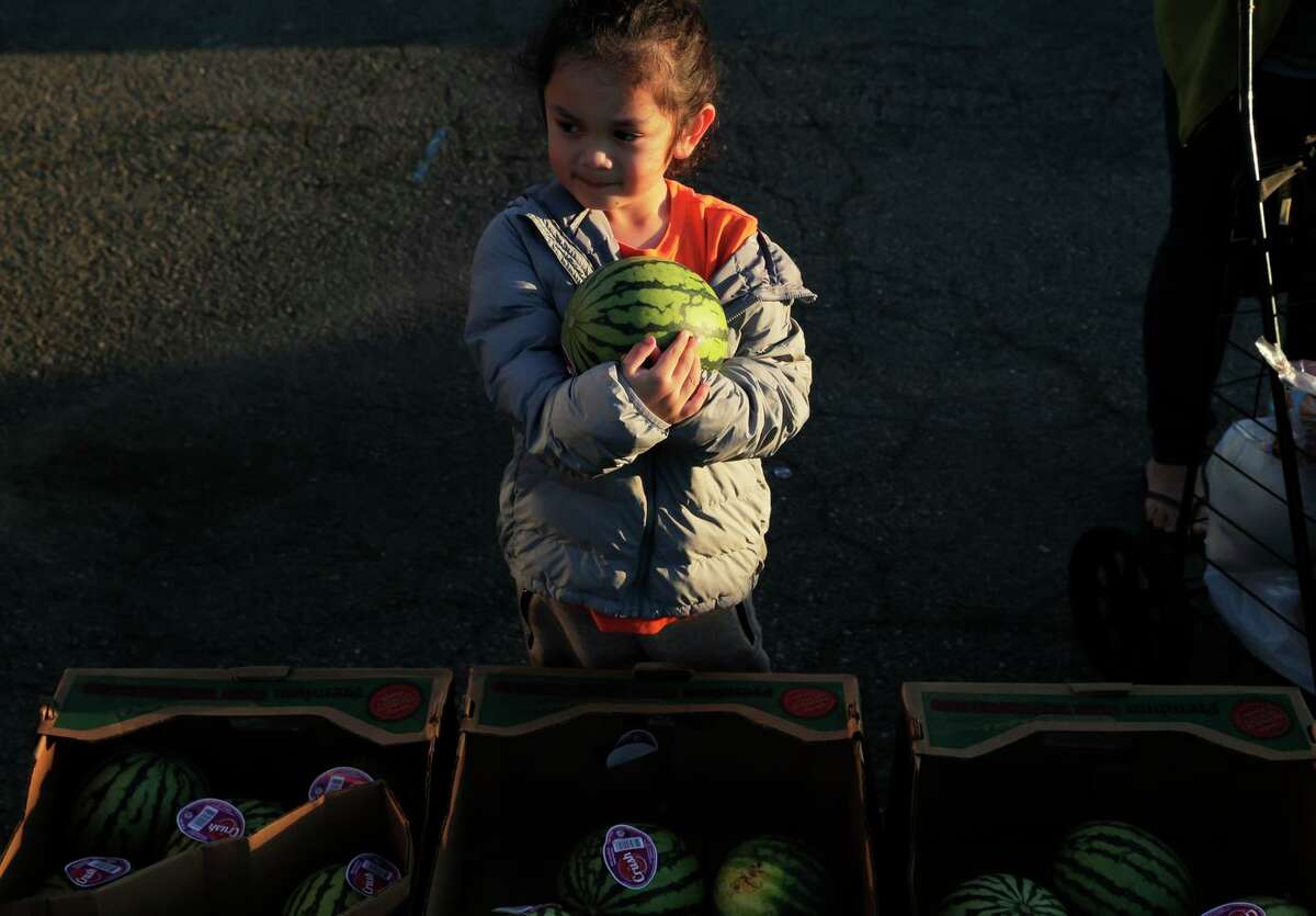 Russell Rodriguez, 4, holds the watermelon he picked at the San Francisco-Marin Food Bank food pantry on Treasure Island in San Francisco.