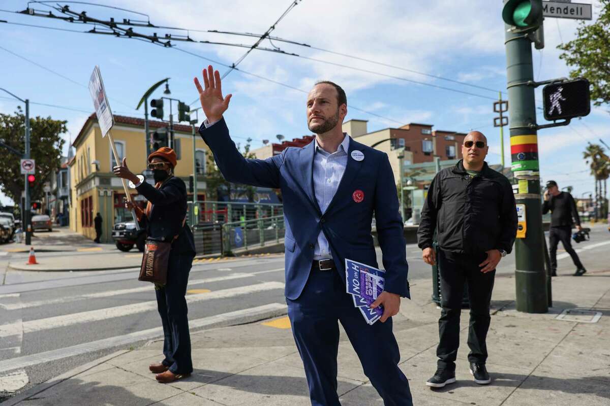District Attorney Chesa Boudin waves at cars honking in support as he canvasses on 3rd Street in the Bayview ahead of the recall on Tuesday, June 7, 2022 in San Francisco, California.