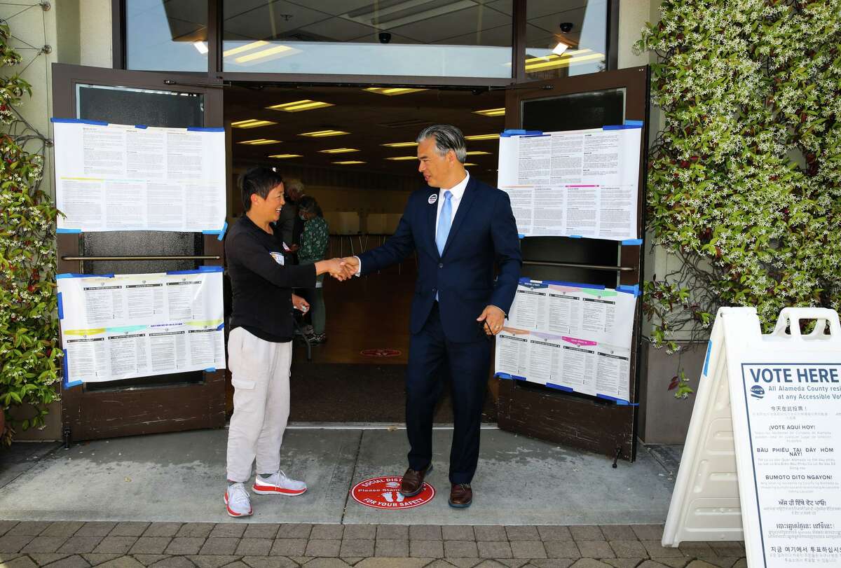 Attorney General Rob Bonta, right, speaks with a poll worker after voting at the South Shore voting precinct on June 7, 2022, in Alameda, Calif.
