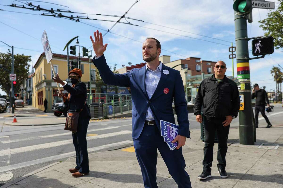 Former D.A. Chesa Boudin waves at cars honking in support as he canvasses on Third Street in the Bayview in San Francisco ahead of the recall vote on Tuesday.
