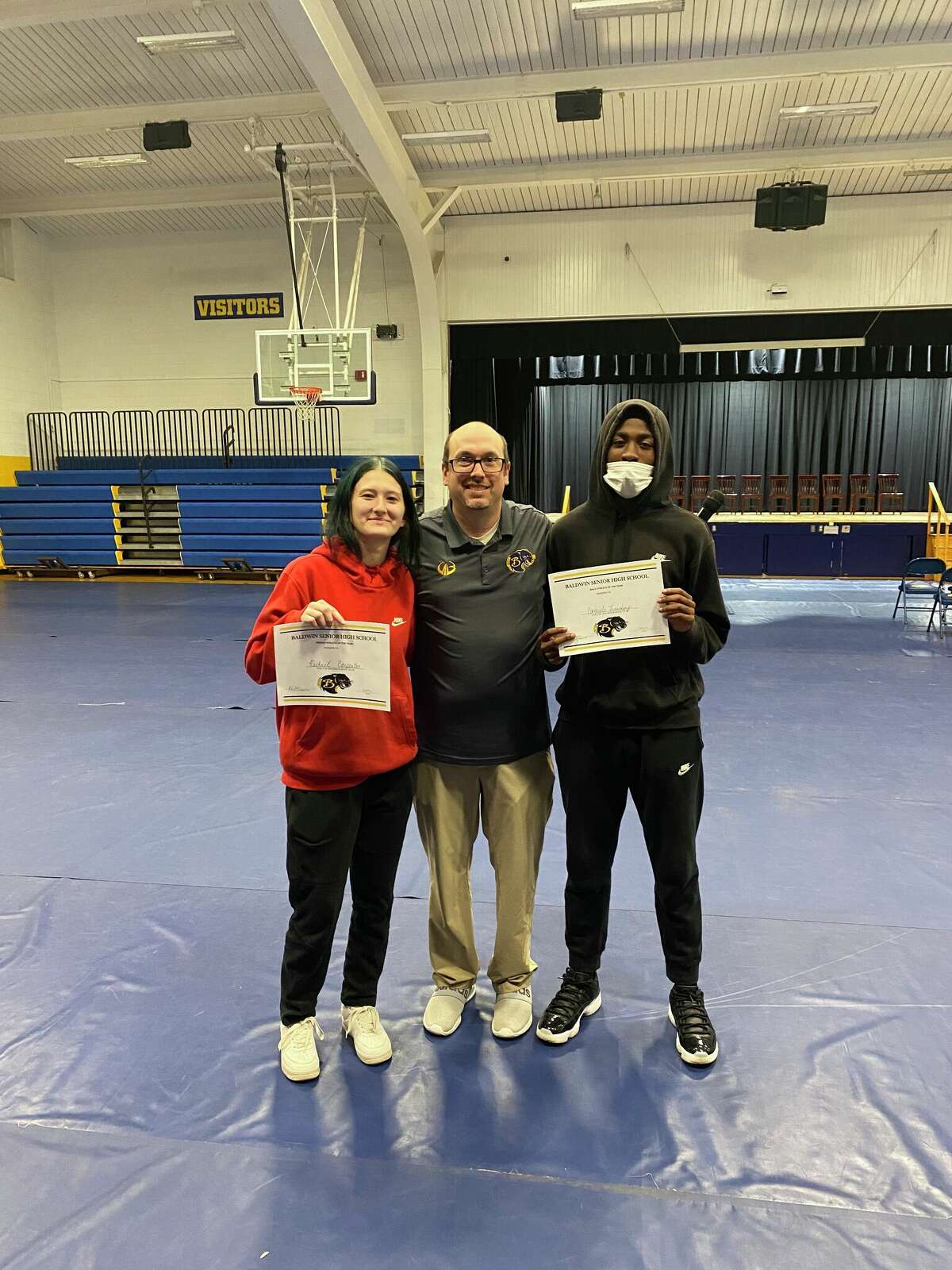 Baldwin athletic director JJ Eads (center) congratulates athletes of the year Rachel Carpenter and Carmelo Lindsey at the recent awards program.