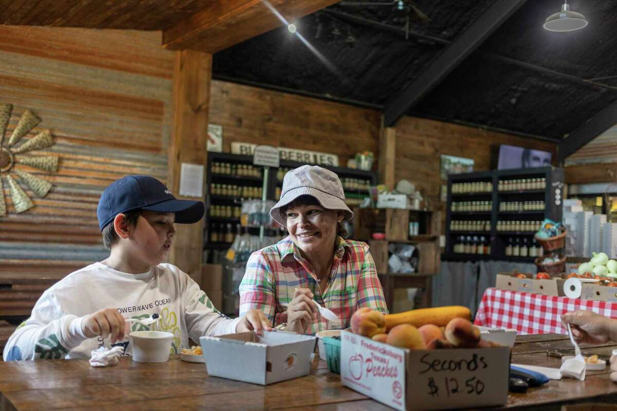 Dustin Gradler, 10, eats peach cobbler with ice cream with Carolina Diaz at Jenschke Orchards in Fredericksburg.