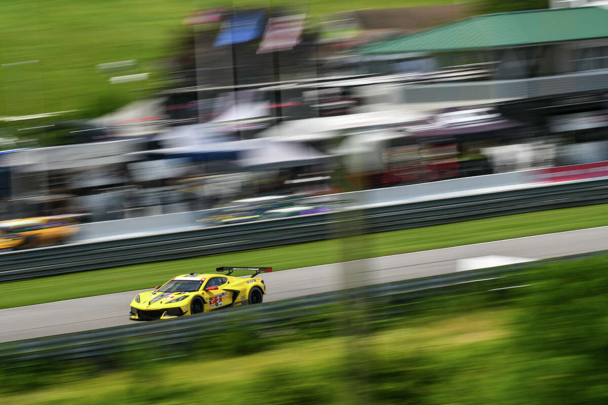 A Corvette C8.R charges down the front straight of the track at Lime Rock Park.