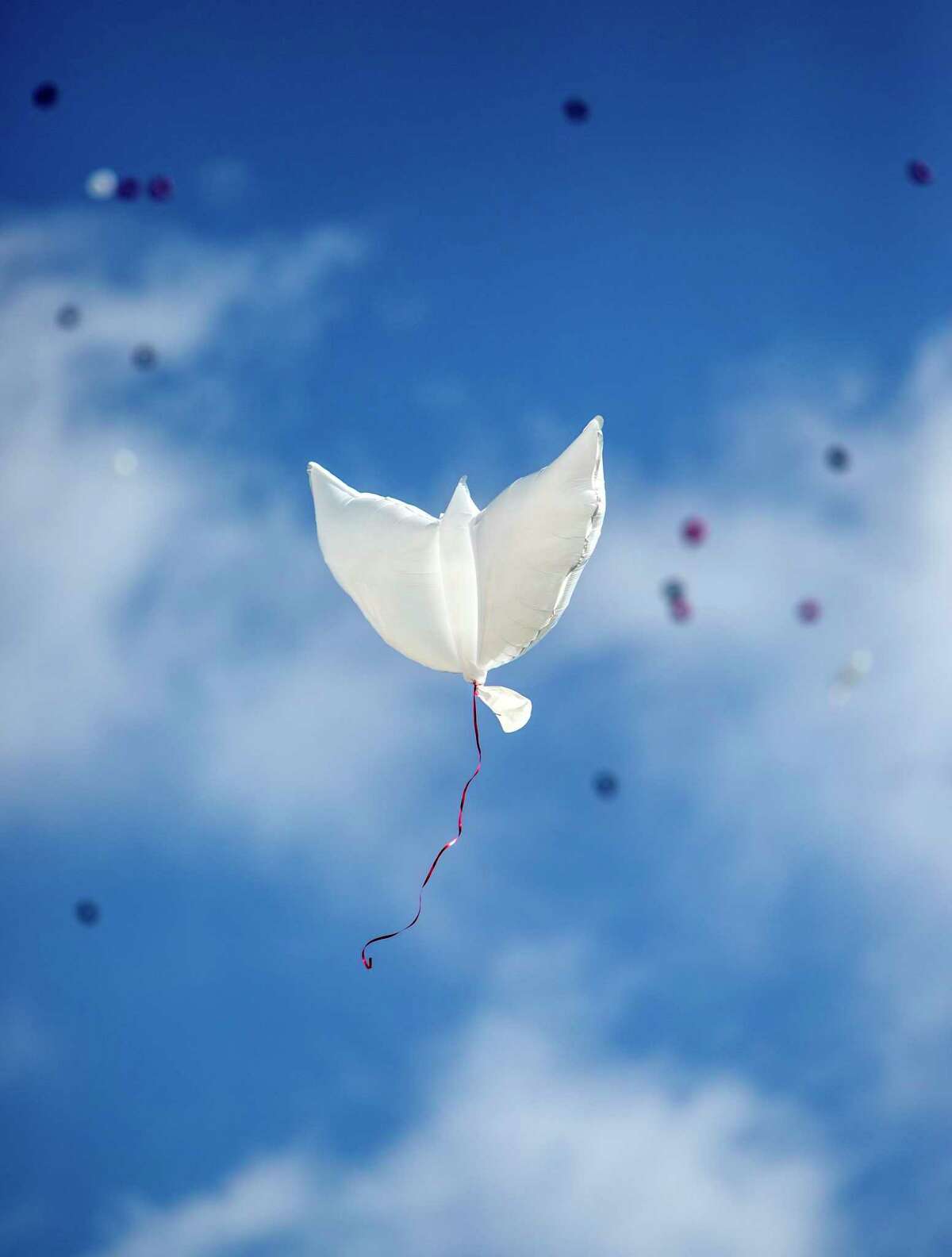 A dove-shaped balloon floats Wednesday into the sky during a balloon released at Antioch Baptist Church in remembrance of the 19 children and two adults killed May 24 at Robb Elementary School in Uvalde by a man with an assault rifle.