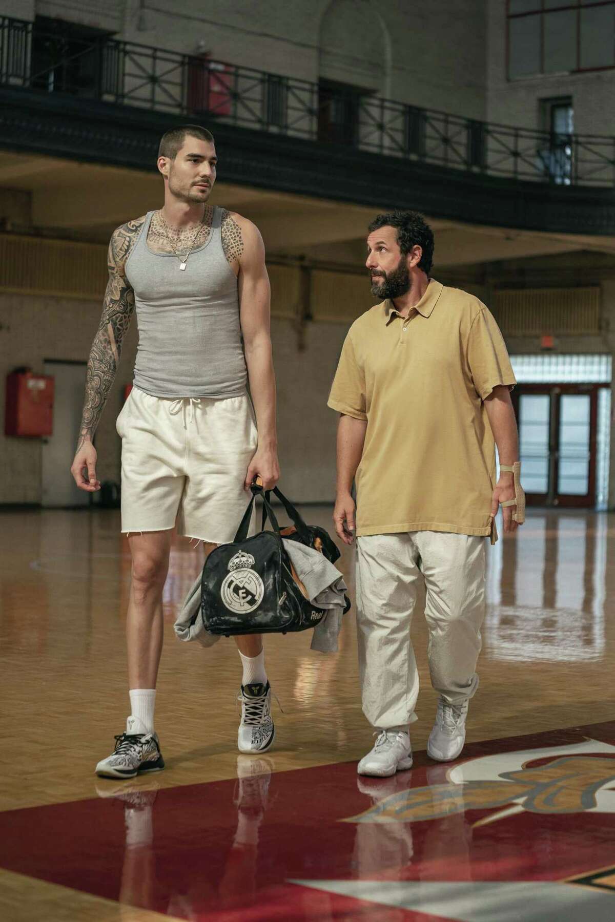 Juancho Hernangomez, left, is the diamond in the rough and Adam Sandler is the guy committed to getting him signed to a team in "Hustle." (Cassy Athena/Netflix/TNS)