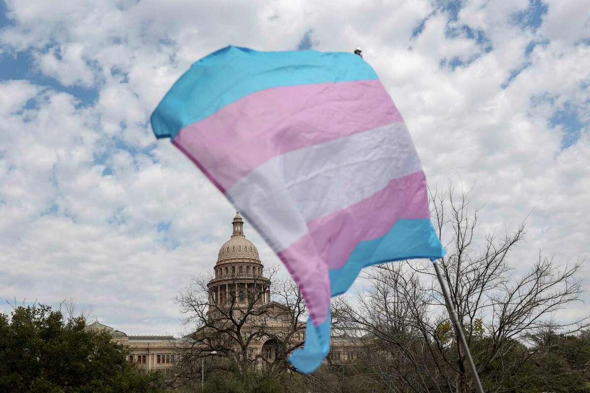 A transgender pride flag flies during a rally for transgender rights held outside the Texas Governors Mansion in Austin, Texas, on March 13, 2022. LGBTQ+ advocates the rally to protest Gov. Greg Abbott's directive allowing the state's child welfare agency to investigate parents who allow their transgender children to receive gender-affirming care as child abusers.
