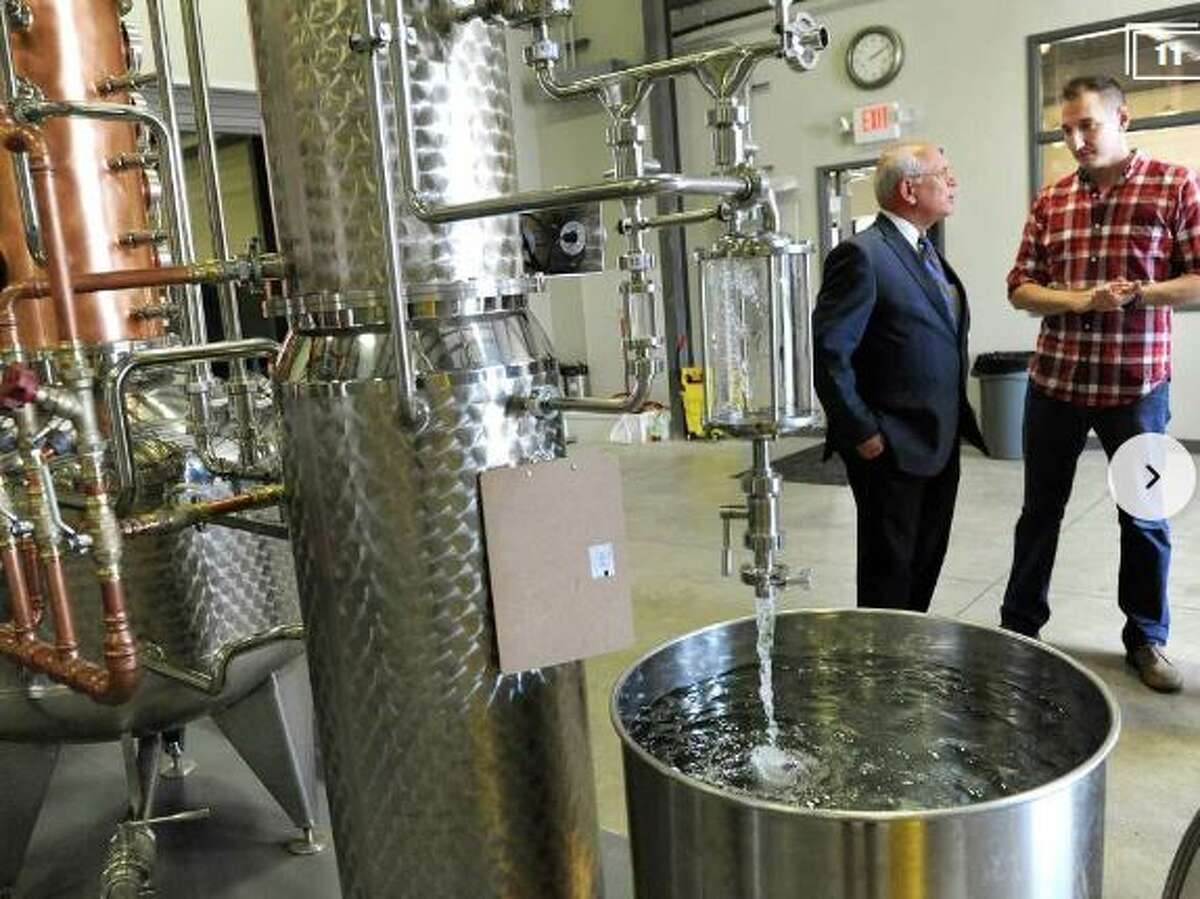 U.S. Rep. Paul Tonko (L) and Yankee Distilleries' Matt Jager discuss whiskey making. Jager made hand sanitizer during the height of the pandemic.