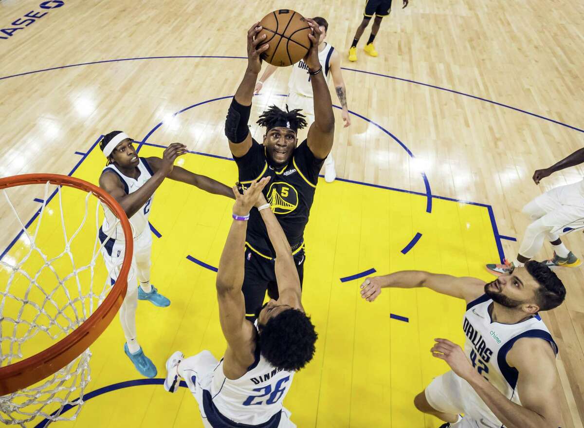 Kevon Looney (5) grabs a rebound amid a trio of Mavericks as the Golden State Warriors defeated the Dallas Mavericks 120-110 in Game 5 of the Western Conference Finals to advance to the NBA Finals at Chase Center in San Francisco, Calif., on Thursday, May 26, 2022.