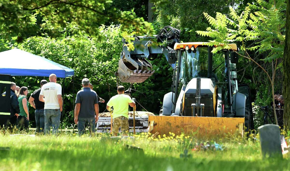 A casket, thought to be that of an unidentified homicide victim from the 1970s, is exhumed at State Street Cemetery in Hamden by the East Haven Police Department June 8, 2022. It turned out not to be the correct gravesite.