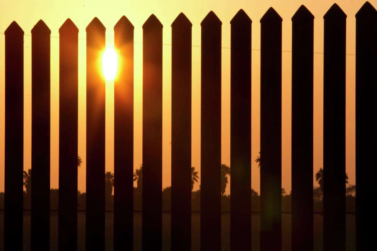 Light from a sun set passes in between the 18-foot, rust-colored U.S-Mexico border fence, Tuesday, June 10, 2014, in Brownsville. ( Marie D. De Jesus / Houston Chronicle )