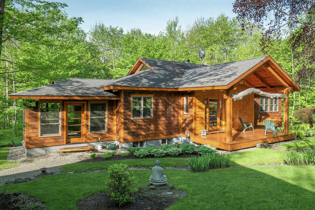 This week’s house is a Japanese-inspired timber frame design on 52.88 acres in Rensselaerville. The house, built in 2006 at 115 Littner Road, has 2,500 square feet of living space on two levels and its private setting in the woods suggests a peaceful, quiet atmosphere. The layout on the first floor is open and cherry trees harvested on the property were included in the support structure. The main living space has a timbered, cathedral ceiling. There are two bedrooms and two and a half bathrooms. Outside, the landscaping includes a 26-foot stream and waterfall.  There is also a cabin and a garage on the property. The cabin, 14-feet by 22-feet, is on the edge of the pond and includes a deck built around a living tree. The garage is 24-feet by 40-feet has three bays, storage and work space. Taxes after exemptions: $10,893. Greenville schools. List price: $890,000. Contact listing agent Hans Soderquist at Cornerpin Realty at 518-336-0125.