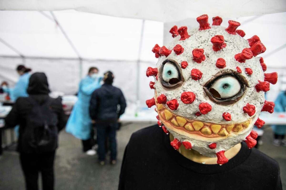 A mannequin in the form of a coronavirus is seen by the entrance to a community testing site managed by Unidos en Salud in the Mission District of San Francisco, California Friday, Jan. 7, 2022.