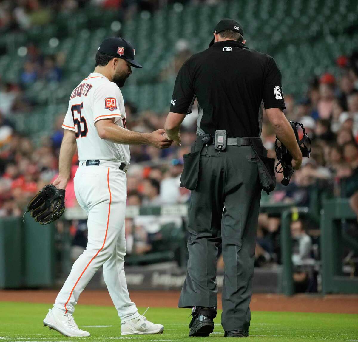 Houston Astros starting pitcher Jose Urquidy (65) gets his hand checked by home plate umpire Ryan Additon after the top of the first inning of a MLB game at Minute Maid Park on Wednesday, June 8, 2022 in Houston.
