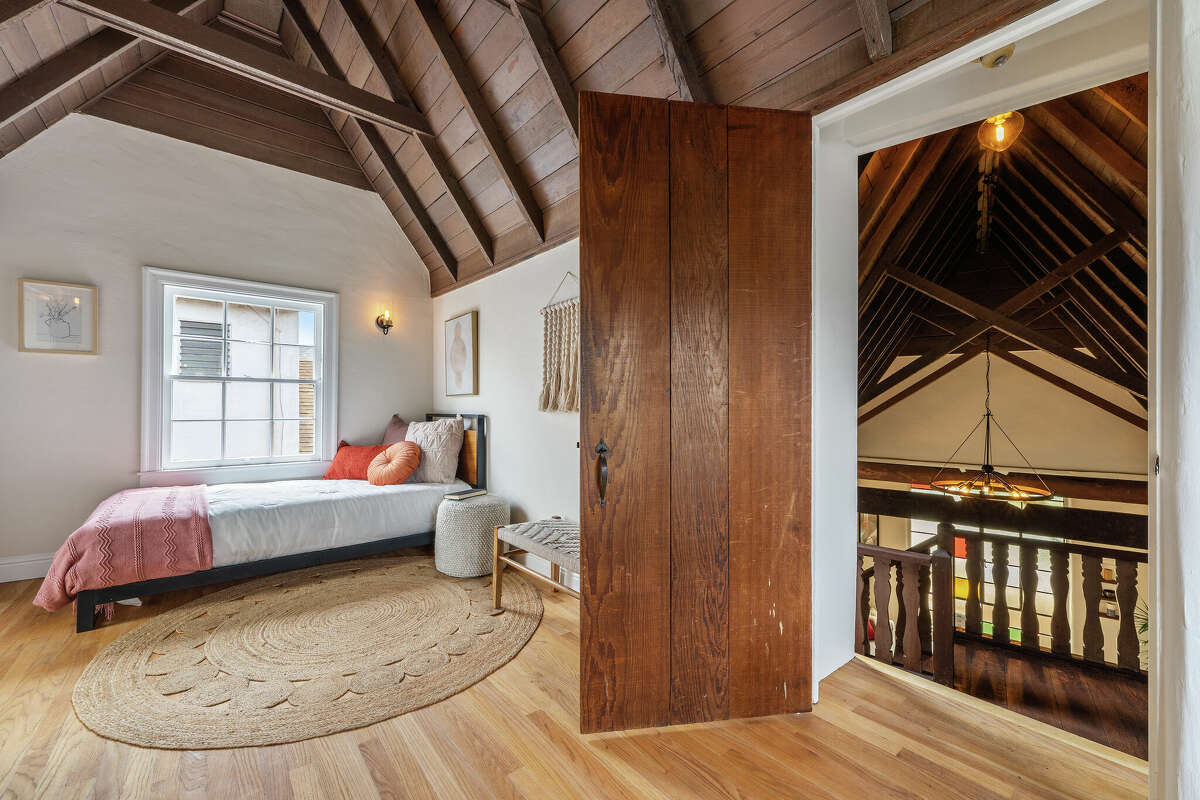 The primary bedroom rests under dark wood cathedral ceilings. 