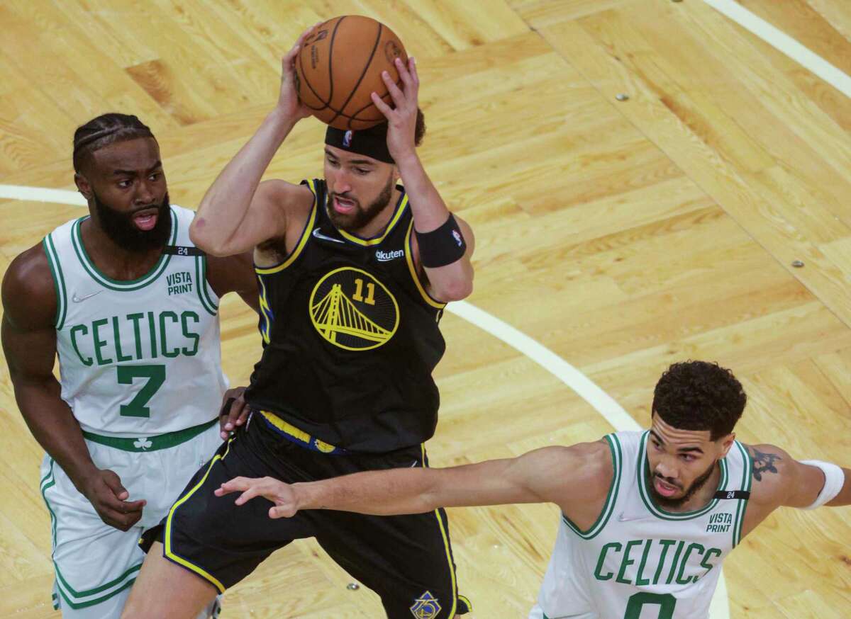 Golden State Warriors' Klay Thompson, 11, tries to get past Boston Celtics' Jaylen Brown, 7, and Jayson Tatum, 0, during the first quarter of the NBA Finals at TD Garden in Boston, Mass., on Wednesday, June 8, 2022.
