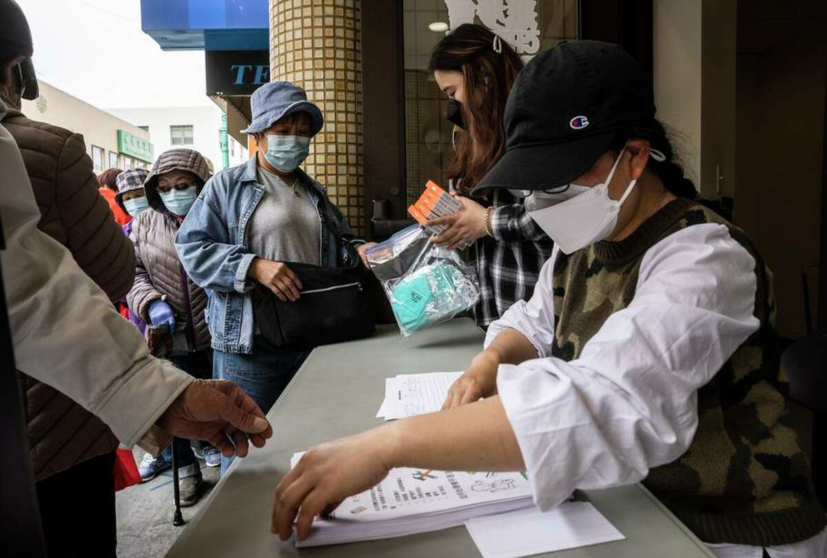 Yulian Luo works at a community event distributing personal protective equipment to SRO residents.