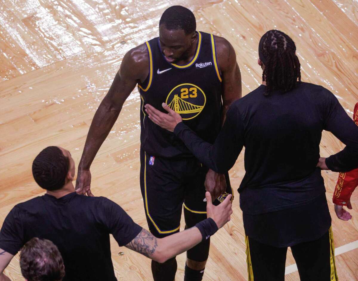 Golden State Warriors' Draymond Green, 23, is greeted at the Warriors’ bench after fouling out in the fourth quarter of the NBA Finals at TD Garden in Boston, Mass., on Wednesday, June 8, 2022.