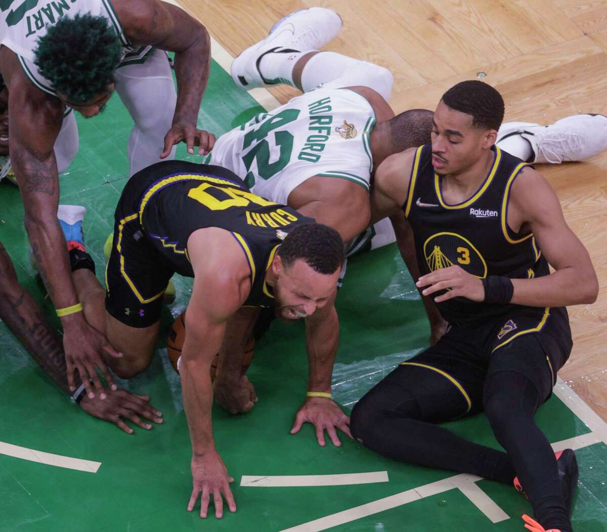 Boston Celtics' Al Horford, 42, falls on Golden State Warriors' Stephen Curry’s, 30, left leg during the fourth quarter of the NBA Finals at TD Garden in Boston, Mass., on Wednesday, June 8, 2022.