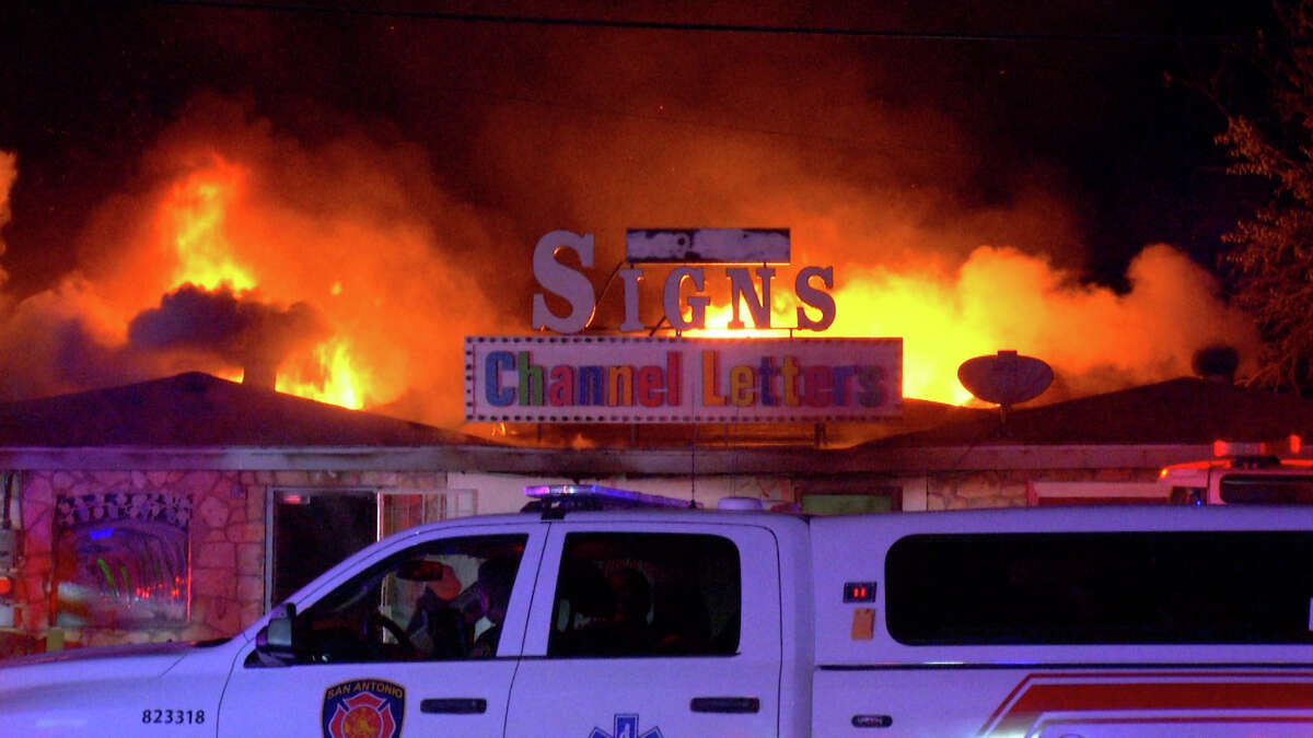 San Antonio firefighters arrived to find the top of the sign shop engulfed in flames early Thursday morning.