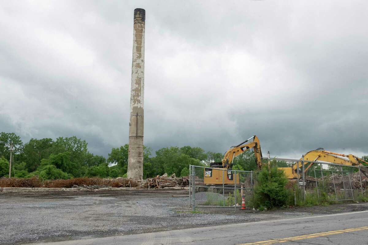 The smoke stack is the only standing structure left of the dilapidated First Prize factory on Thursday, June 9, 2022 in Colonie, N.Y. Demolition crews are working to clear the structure which has been an eye sore for many years.