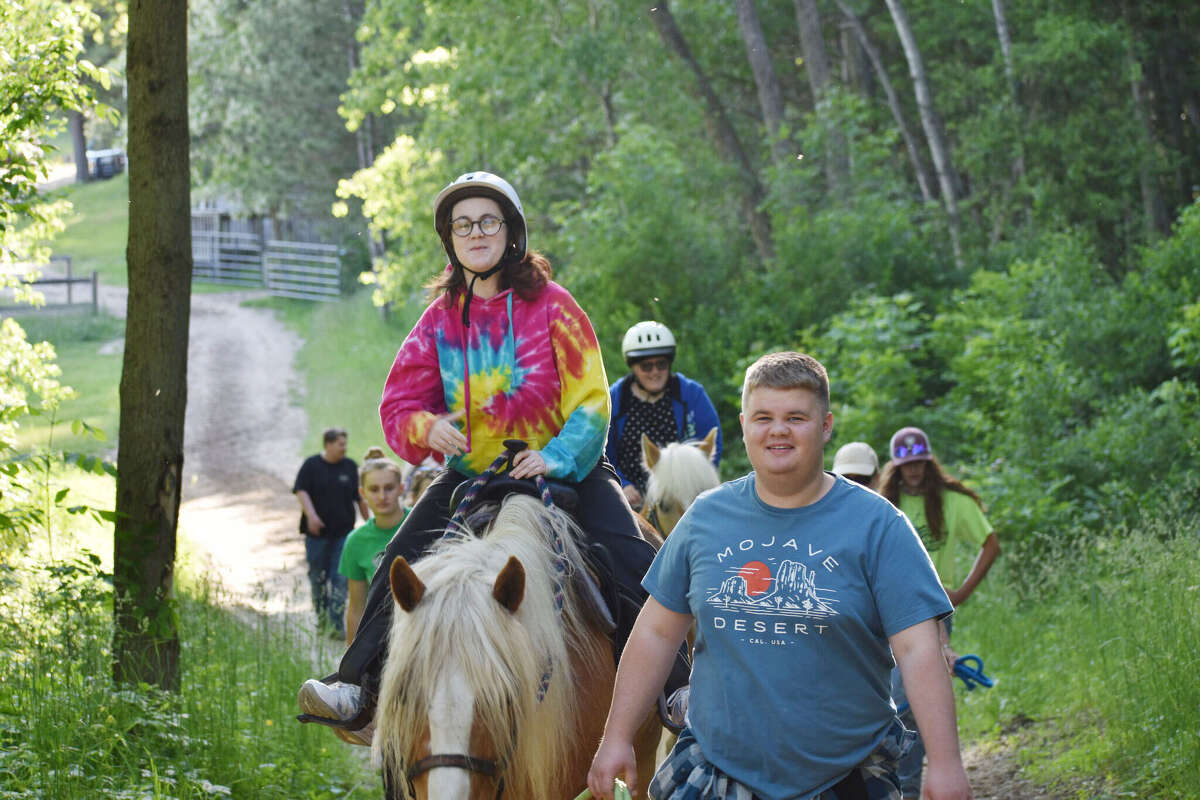 Proud Equestrian Program participants went on a trail ride as the final night of the spring program Tuesday, June 7. Above, Marissa Wildey rides her horse Pippen while volunteer Eli Vincent leads.