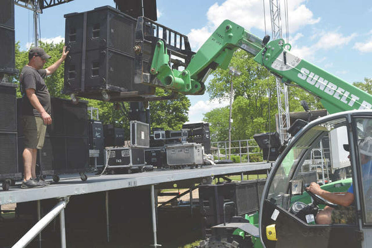 Jason Hebron (left) of Mason Sound works to set stages at the Sangamon County Fairgrounds in New Berlin ahead of the fair’s live concerts in 2021.