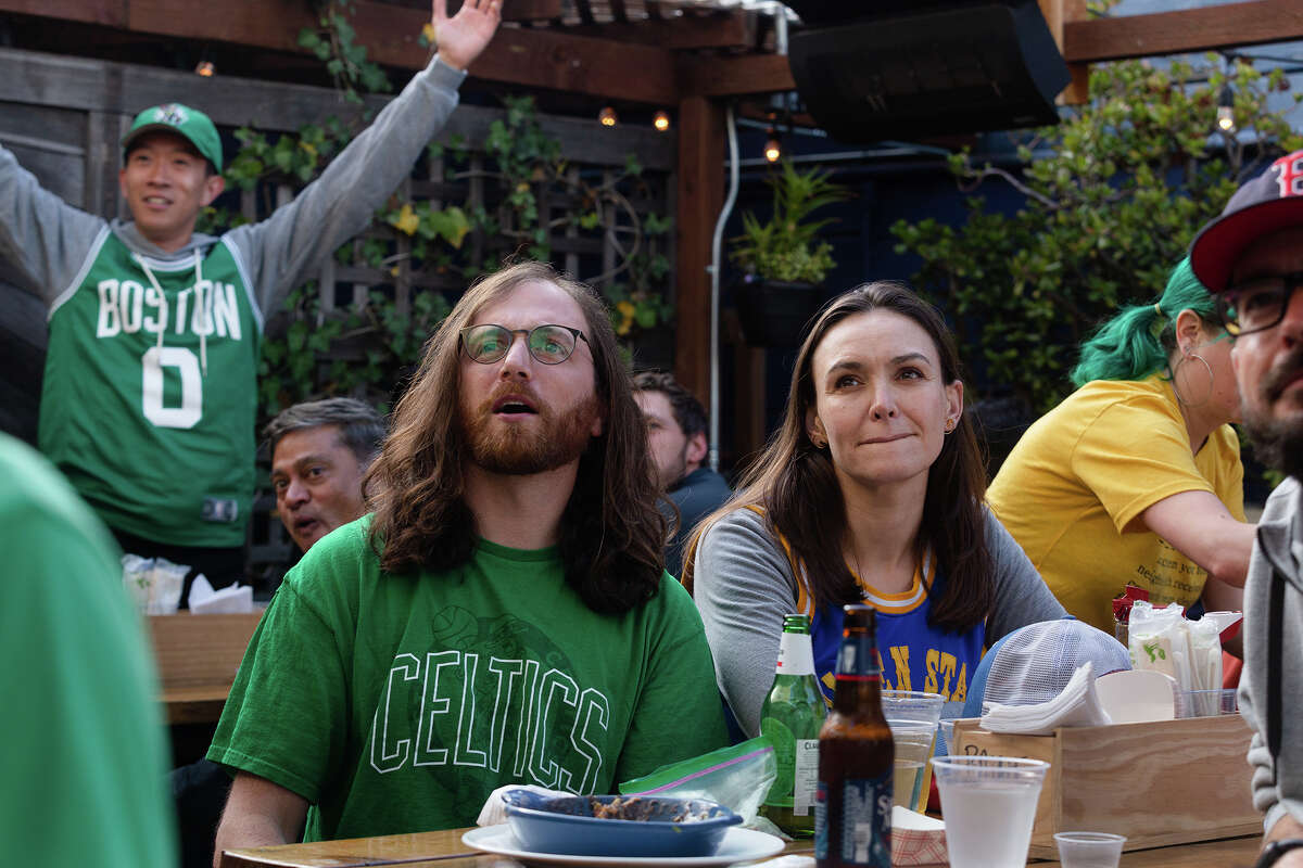 Alex Yule, center, watches Game 3 with partner Kate Roberts, as Will Hui, back left, reacts to a play on the outdoor patio of Connecticut Yankee, on Wednesday, June 8, 2022. 