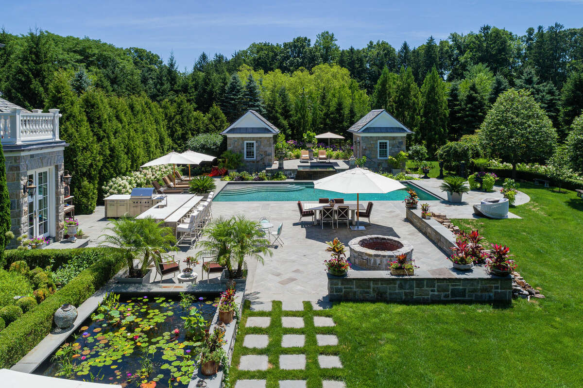 Complementing the seven bedroom, 9,750-square-foot manor in the Andrews Farm Association are an inviting pool and terrace, a built-in fire pit, outdoor kitchen and beautifully landscaped lawn and gardens.