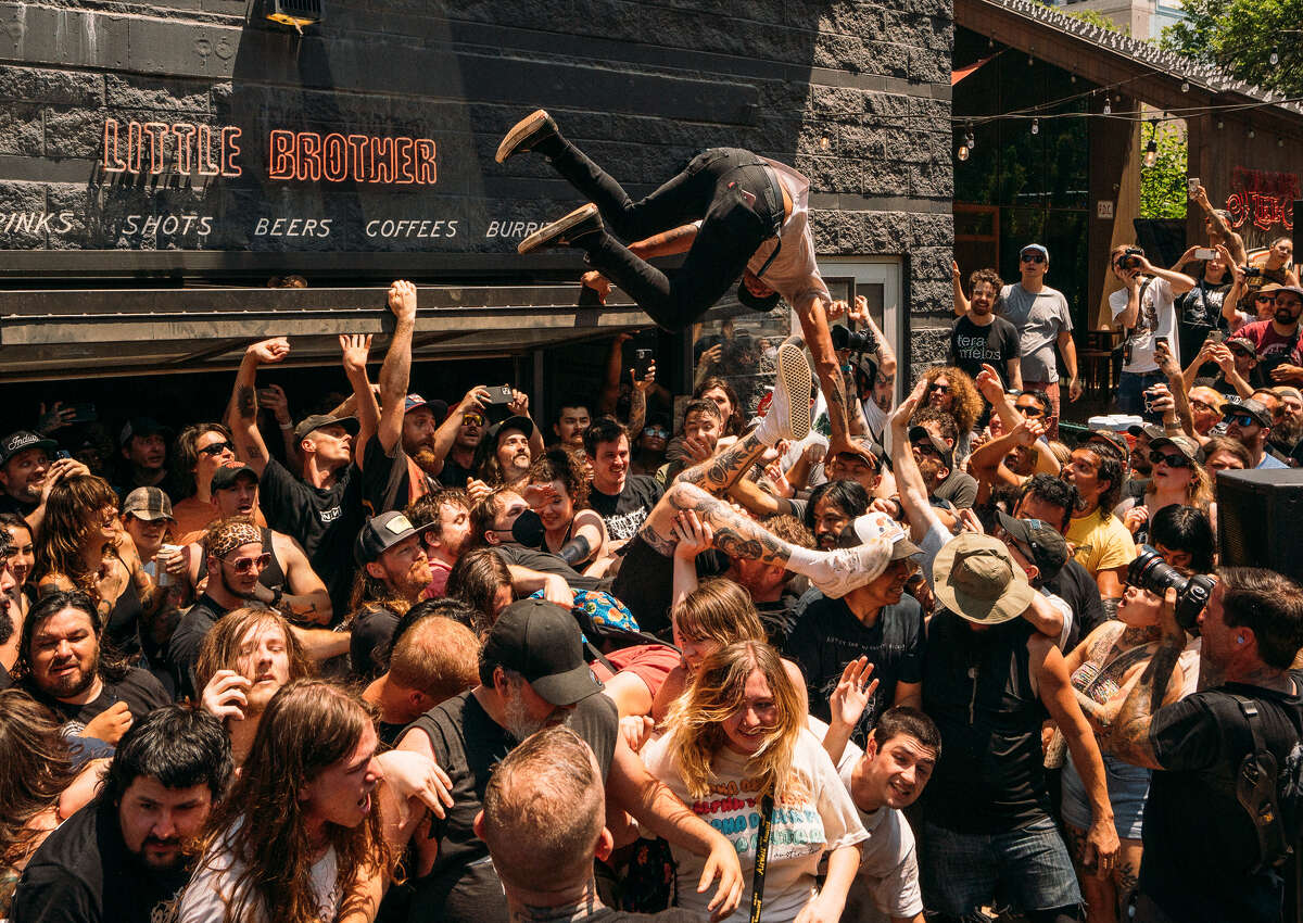 A fan dives off the awning of Little Brother bar during a recent Converge show.