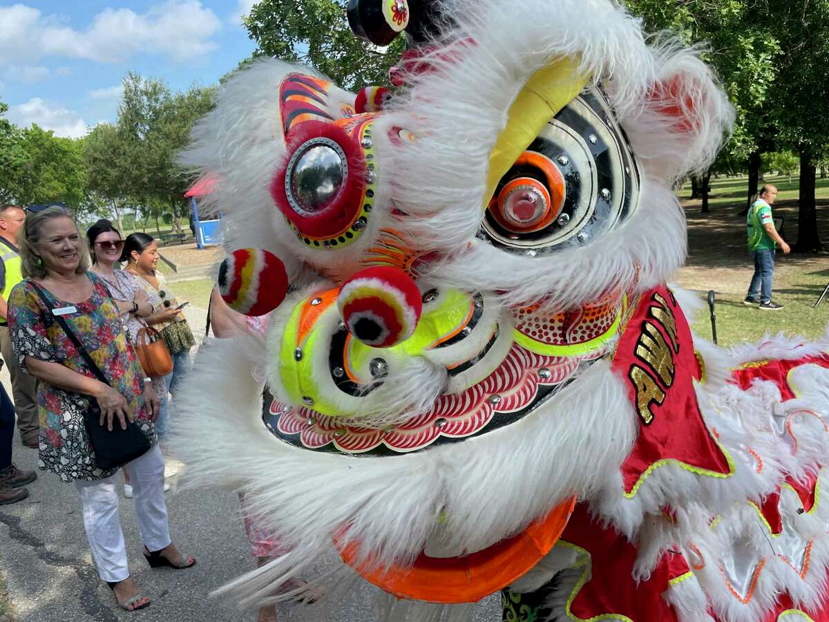 A member of the Teo Chew Association Unicorn Dragon and Lion Dance Team performs through the crowd at a construction opening for a new 7.7 mile segment of Brays Bayou trail at Art Storey Park in Houston on June 9, 2022.