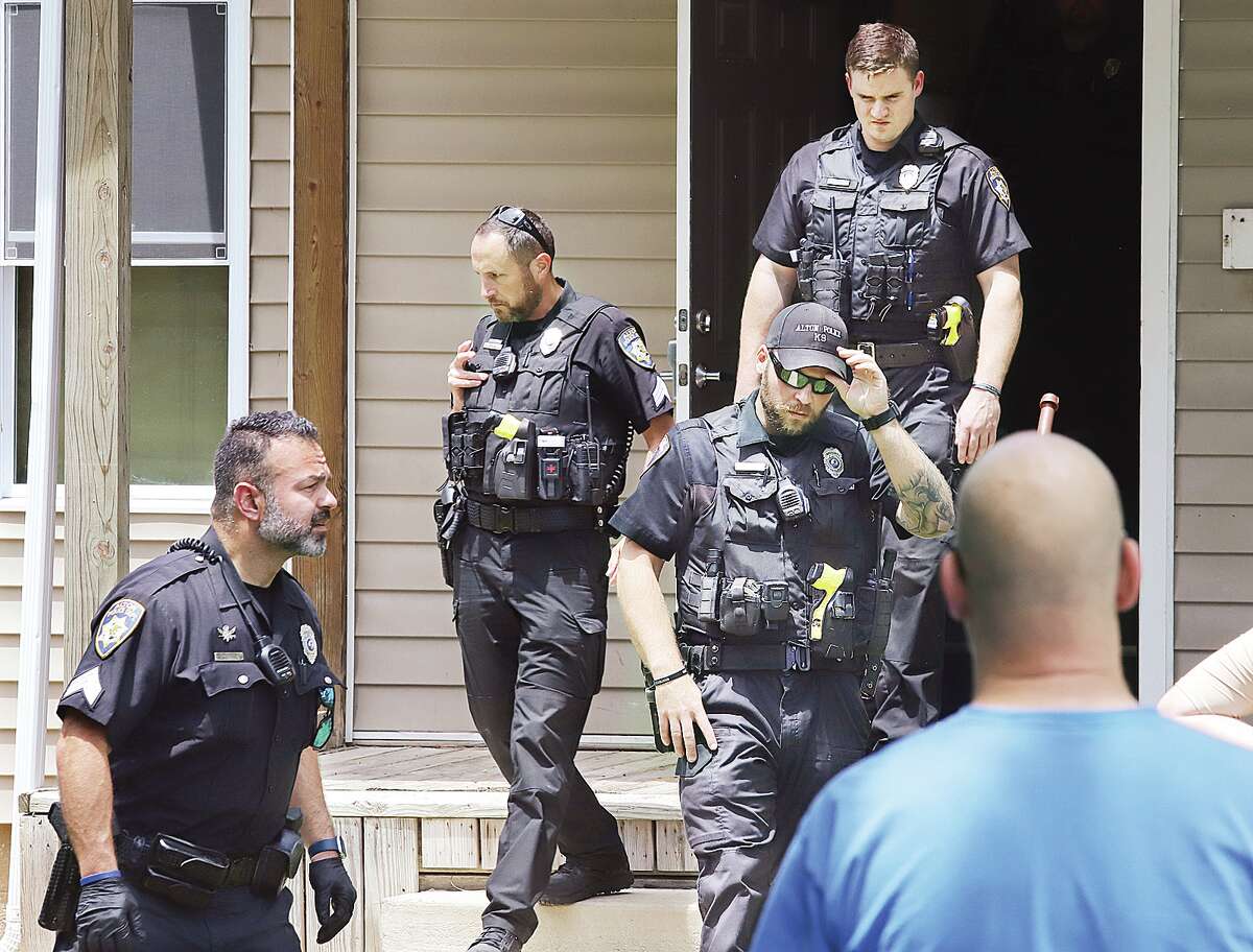 John Badman|The Telegraph Alton officers file out of the apartment building after searching all four apartments. The officers entered the units with guns drawn using a key from the property owner. No other victims were found.