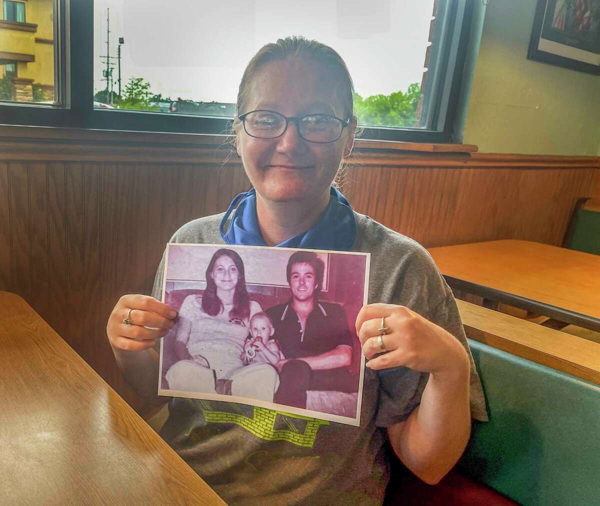 Holly Marie holds a picture of herself as a baby with her late parents, Harold Dean Clouse and Tina Gail Linn.