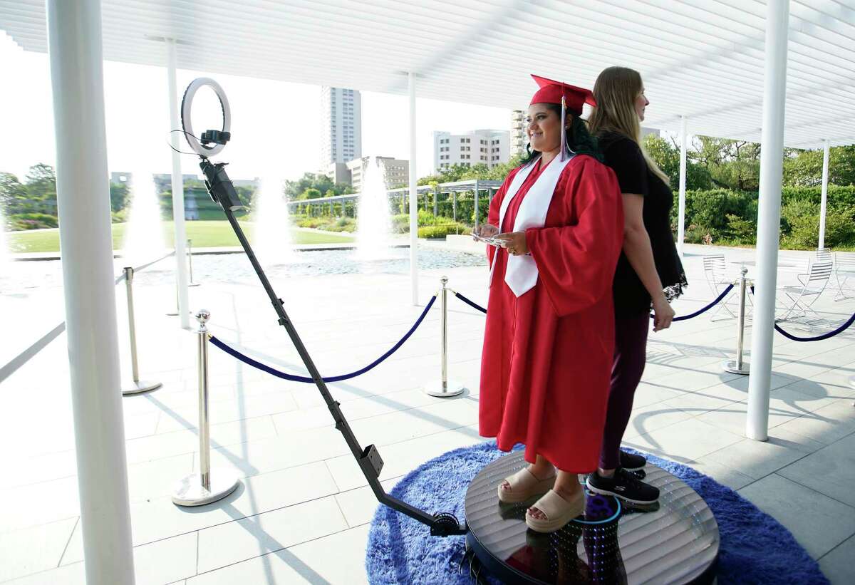Elida Zepeda, 20, wears her gown from Atascocita High School gets her photo taken with her foster mom, Jessica Tenbrook, on the 360 degree photo booth run by TJ Tegu Entertainment, during a celebration of Houston area CPS foster youth who are graduating high school and aging out of foster care, at Cheri Flores Garden Pavilion on Thursday, June 9, 2022 in Houston. Nearly 100 foster youth in the greater Houston area are graduating high school this month. The HAY Center, Harris County Resources for Children and Adults , Judge Lina Hidalgo, and other community leaders recognized these amazing foster youth for achieving this great milestone, despite the obstacles they have faced. Zepeda wants to go to college and become a flight attendant.