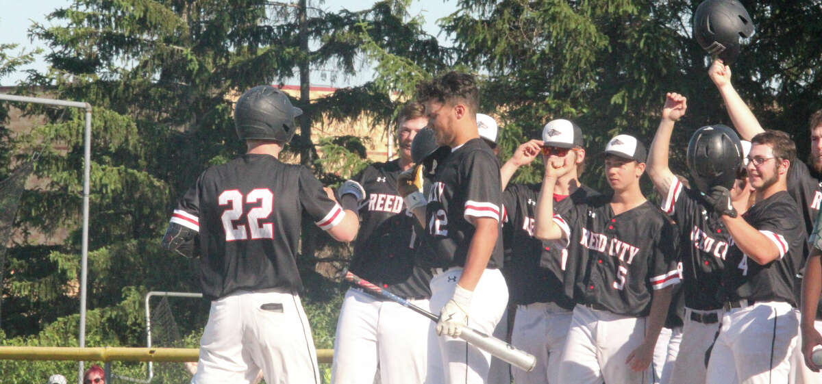 Max Hammond (22) is greeted at home plate on Thursday by his teammates after his grand slam home run against Pine River.