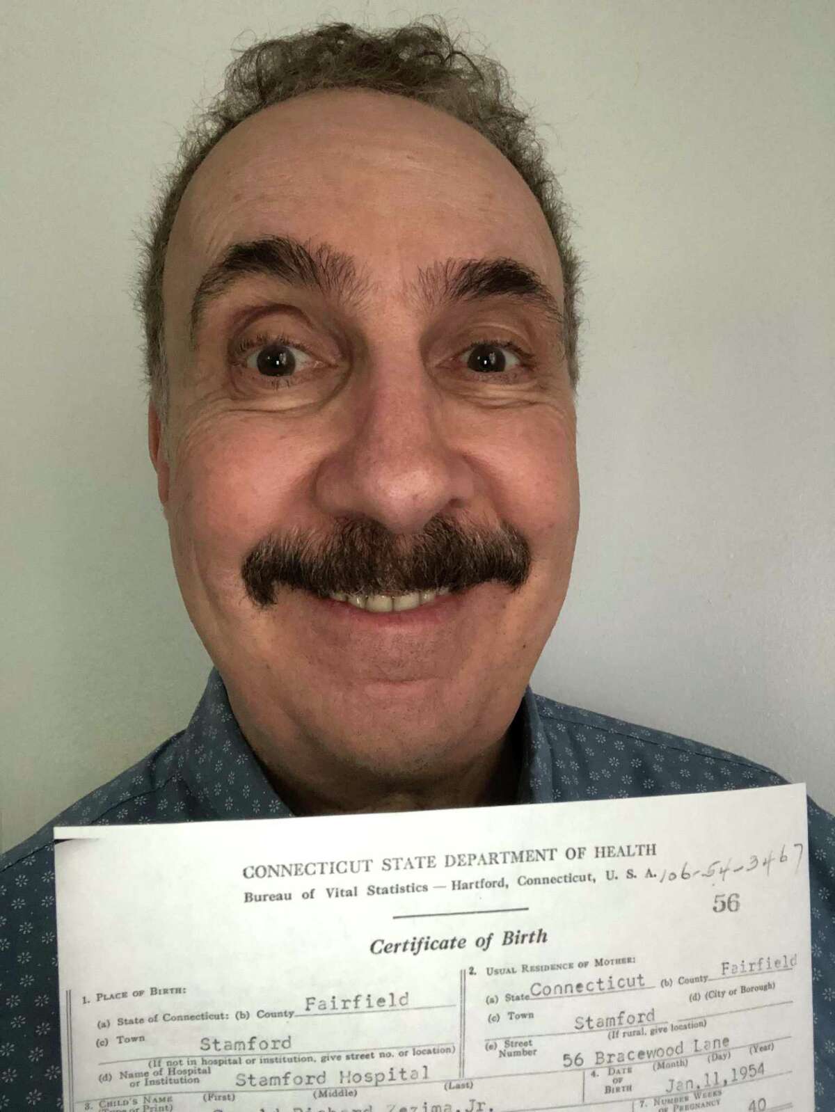Jerry Zezima holds his birth certificate.