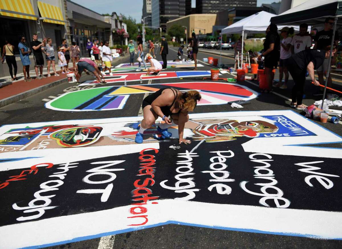 Artists participate in the Black Lives Matter mural restoration at the Juneteenth celebration in Stamford in 2021.