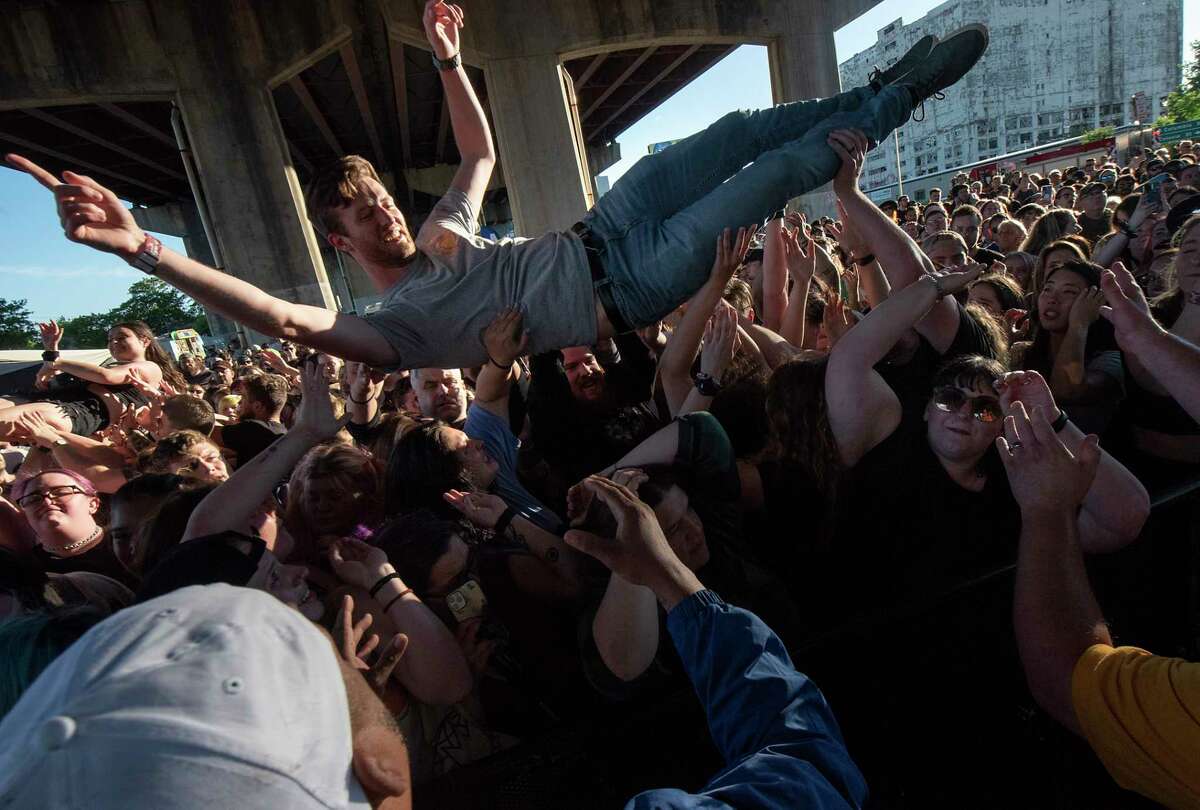 Fans body surf to the pit in front of the stage as State Champs perform during Alive at Five at the Corning Preserve on Thursday, June 9, 2022 in Albany, N.Y. Albany's eight-week Alive at 5 series of free concerts on Thursday nights at the riverfront amphitheater starts with a show by Young Culture with State Champs. The concert was held under I-787 which is the rain location.