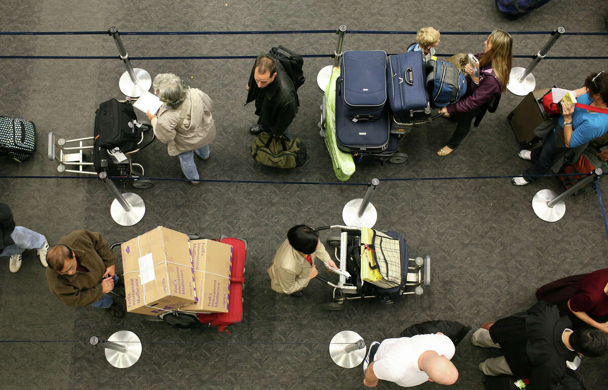 Travelers wait in line to check in for their flights at San Francisco International Airport.