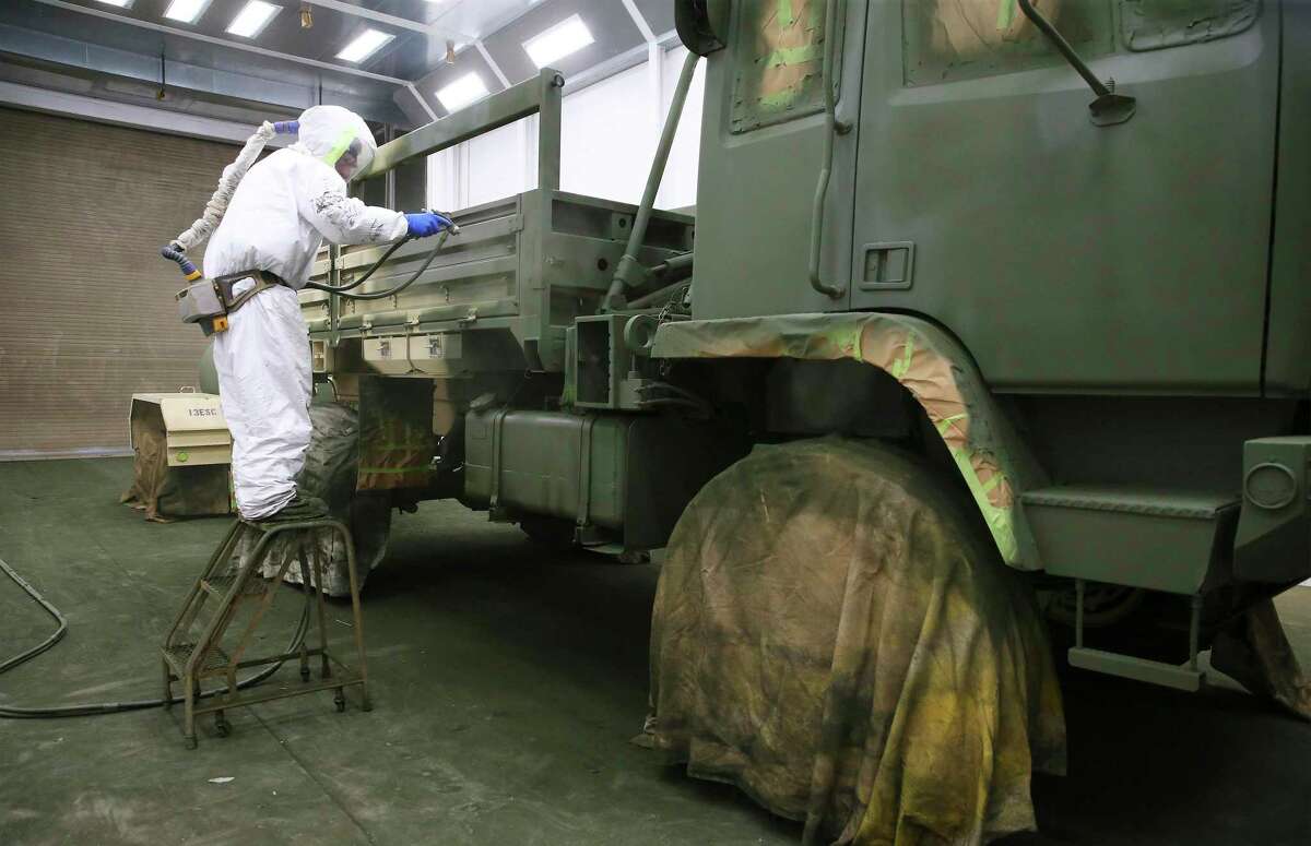 David Stidham, a civil service worker, sprays a panel on a military vehicle at Fort Hood on May 19. After 20 years of fighting wars in vehicles painted to match the desert, the Army has started painting its vehicles “woodland green.” There are thousands more to go on a post that is home to the 1st Cavalry Division and other first-to-fight units.