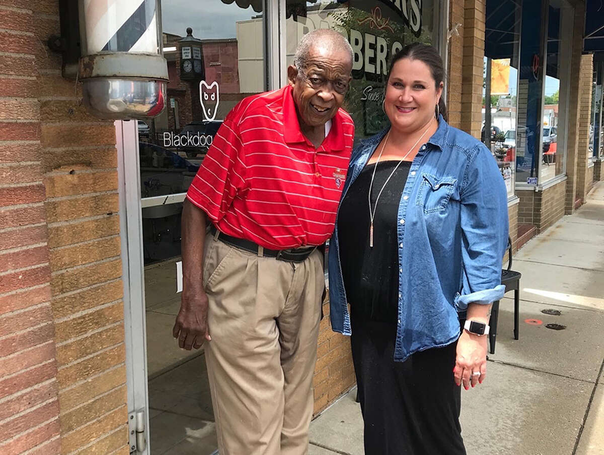 Marvin “Preach” Webb with store owner Kari Eaker outside Eaker’s Family Barbershop in Edwardsville. 