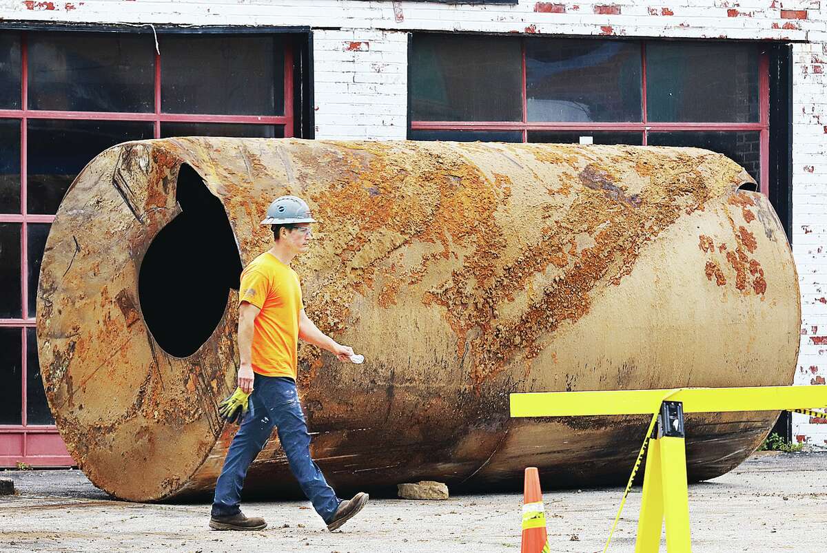 John Badman|The Telegraph A worker walks past one of three underground fuel storage tank removed from 443 East Broadway in Alton this week under the supervision of the Illinois State Fire Marshals Office. 
